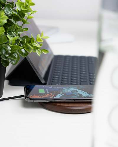 computer hardware black smartphone turned on beside green plants computer keyboard